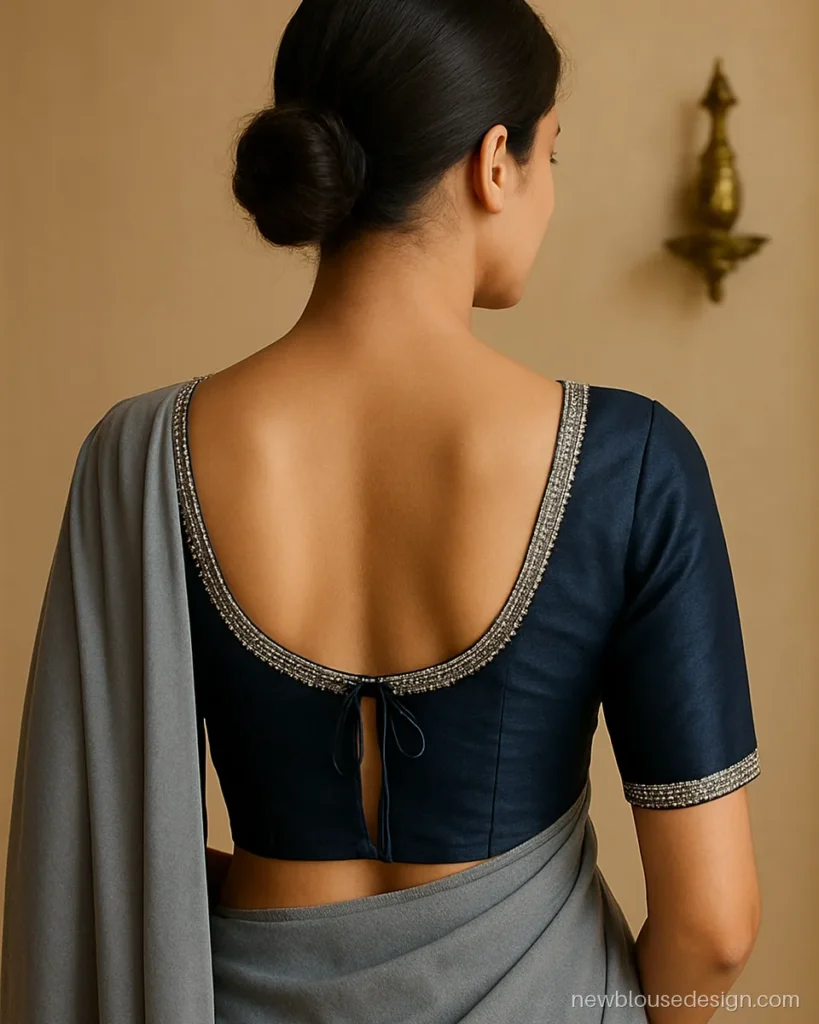 Aari work back blouse design in navy silk with a deep U and a sequin and bead border