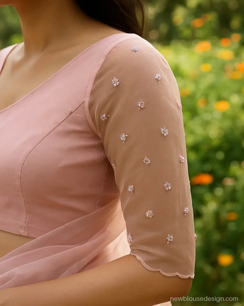Pink aari work blouse design with sheer organza sleeves and scattered thread flowers