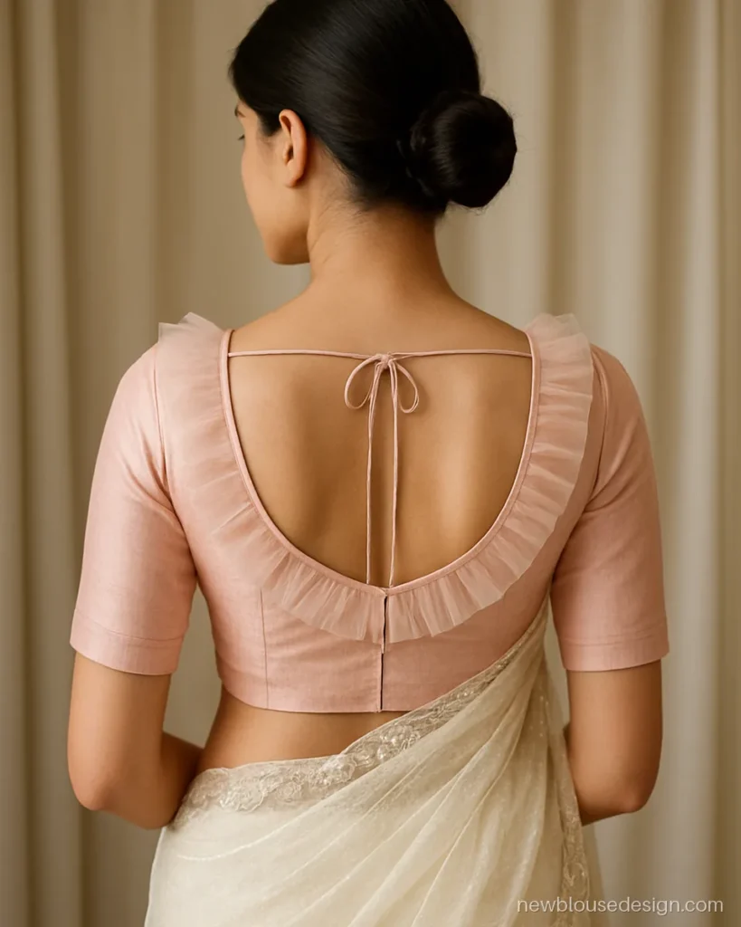 Blush tulle backless blouse with a ruffled edge along the back