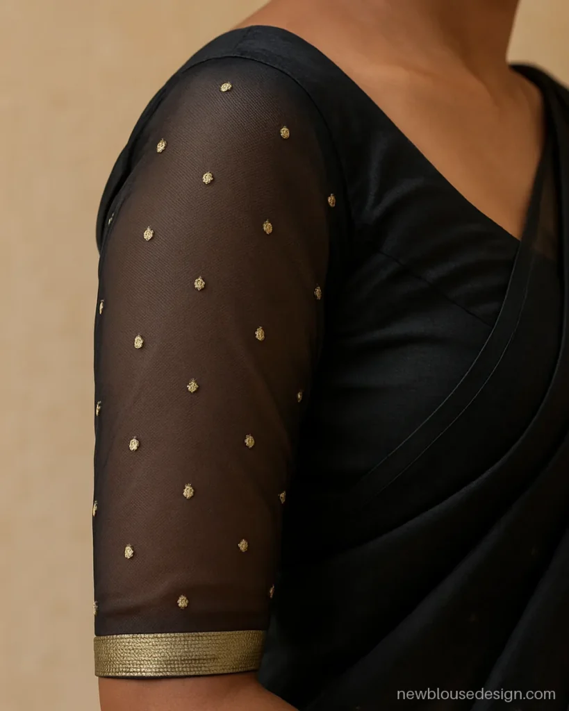 Black full sleeves blouse with sheer net and gold buti on the arms
