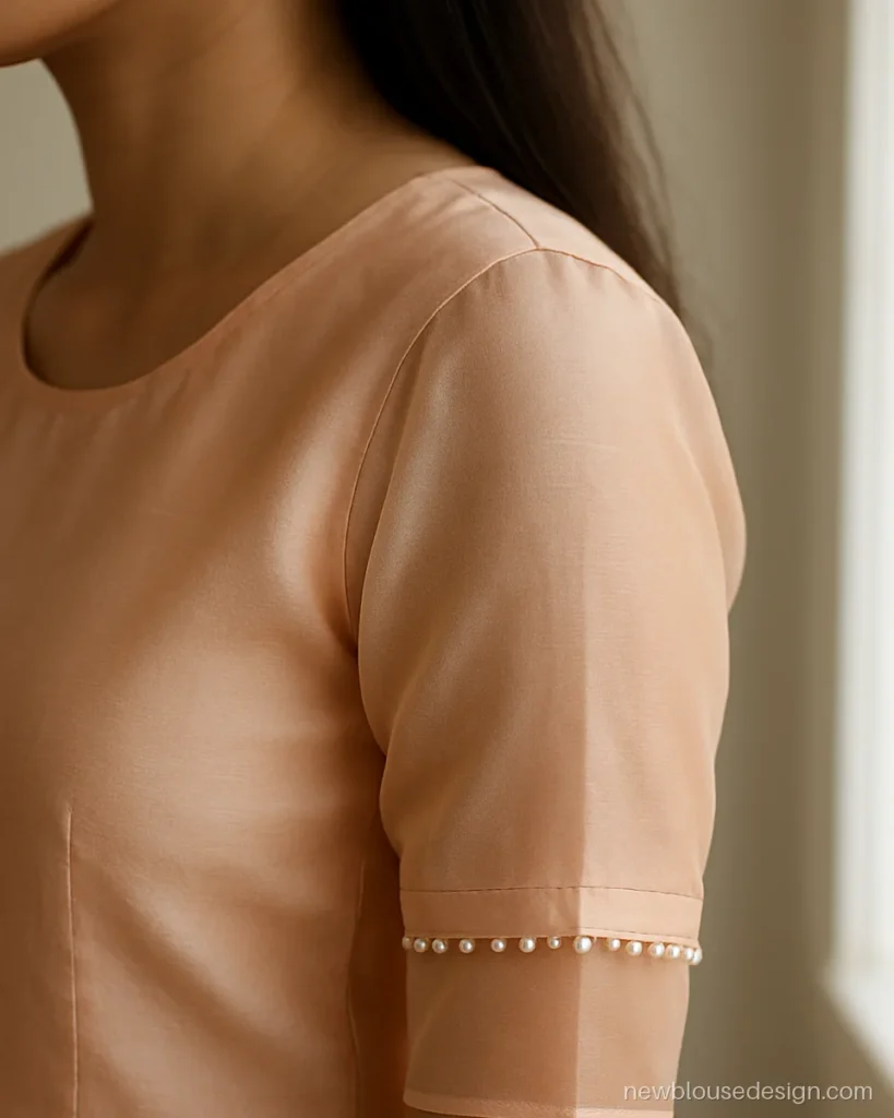 Peach blouse with sheer organza sleeves and pearl edge