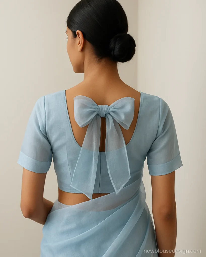 Frill blouse design back side in powder blue organza with a frilled bow at the neck