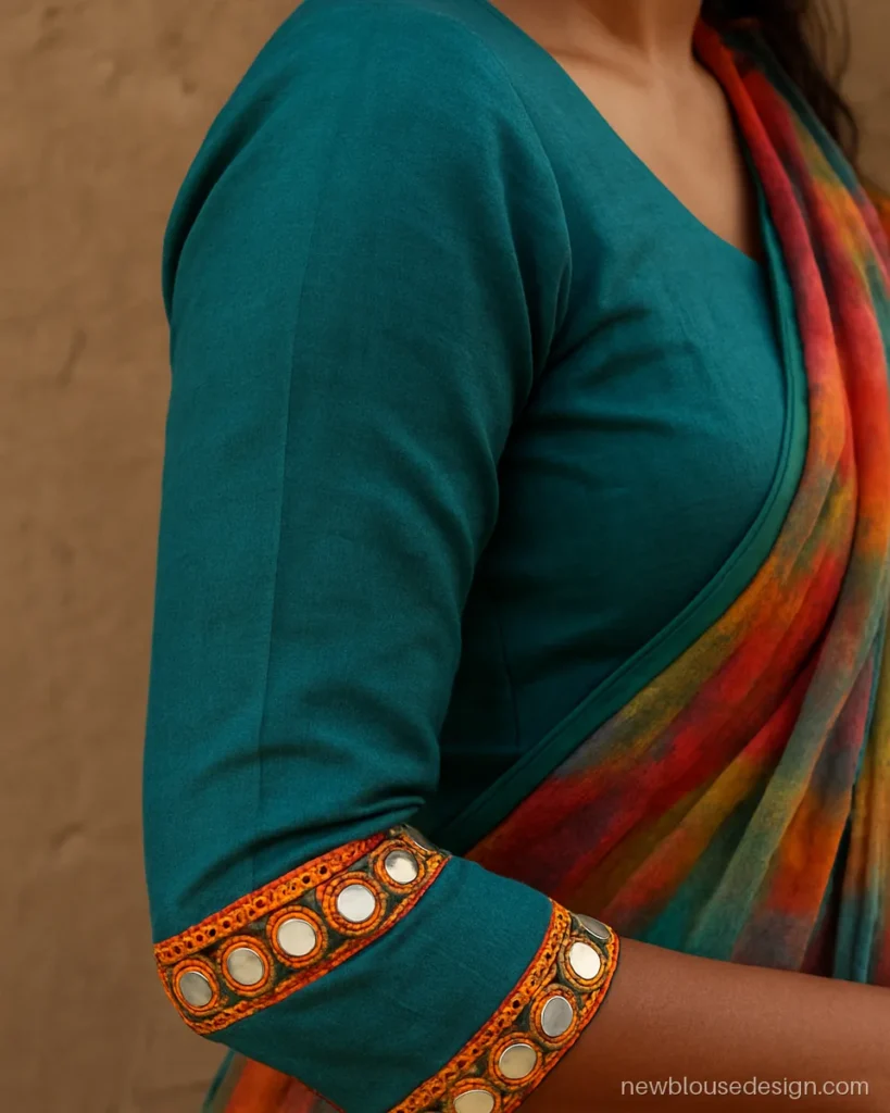 Teal lehenga blouse with full sleeves and round mirror work on the cuffs