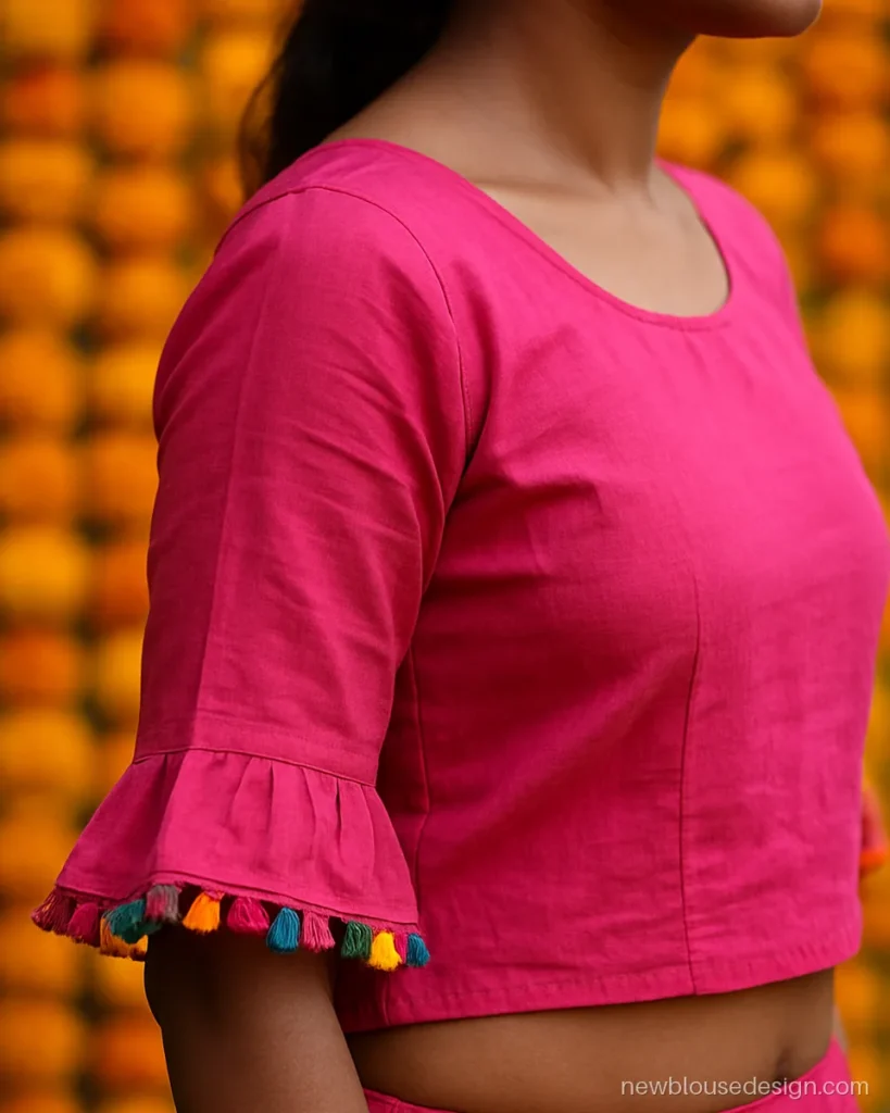Pink cotton choli with elbow bell sleeves edged in small tassels