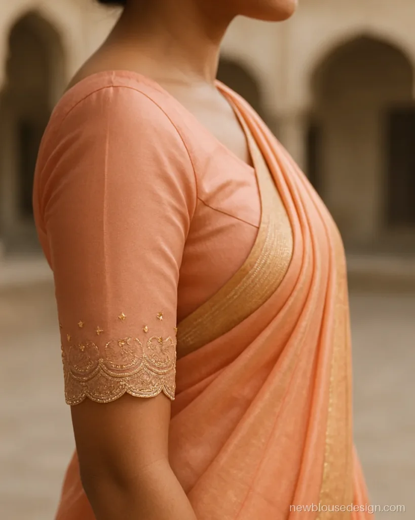 Peach blouse with elbow length net sleeves and scalloped embroidered hem