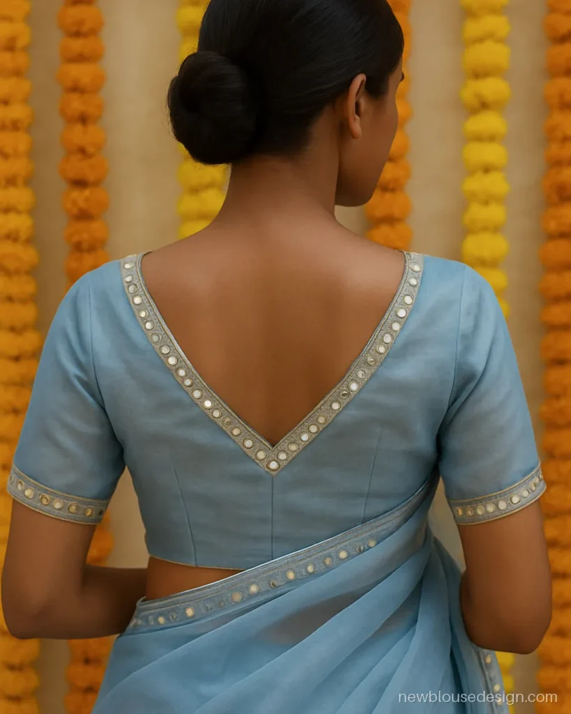 Powder blue organza blouse with a V back and small mirror work